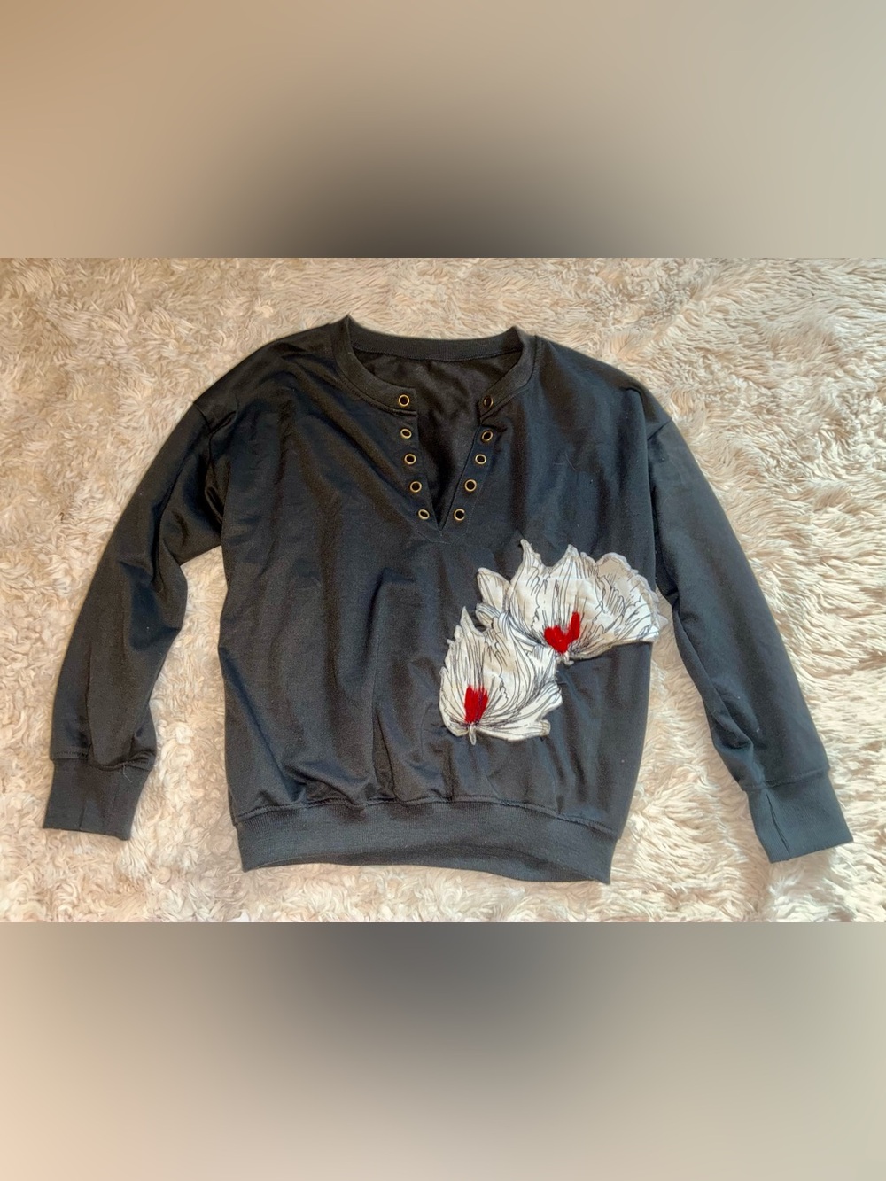 Black Pullover Sweatshirt with Floral Applique and Grommet Neck